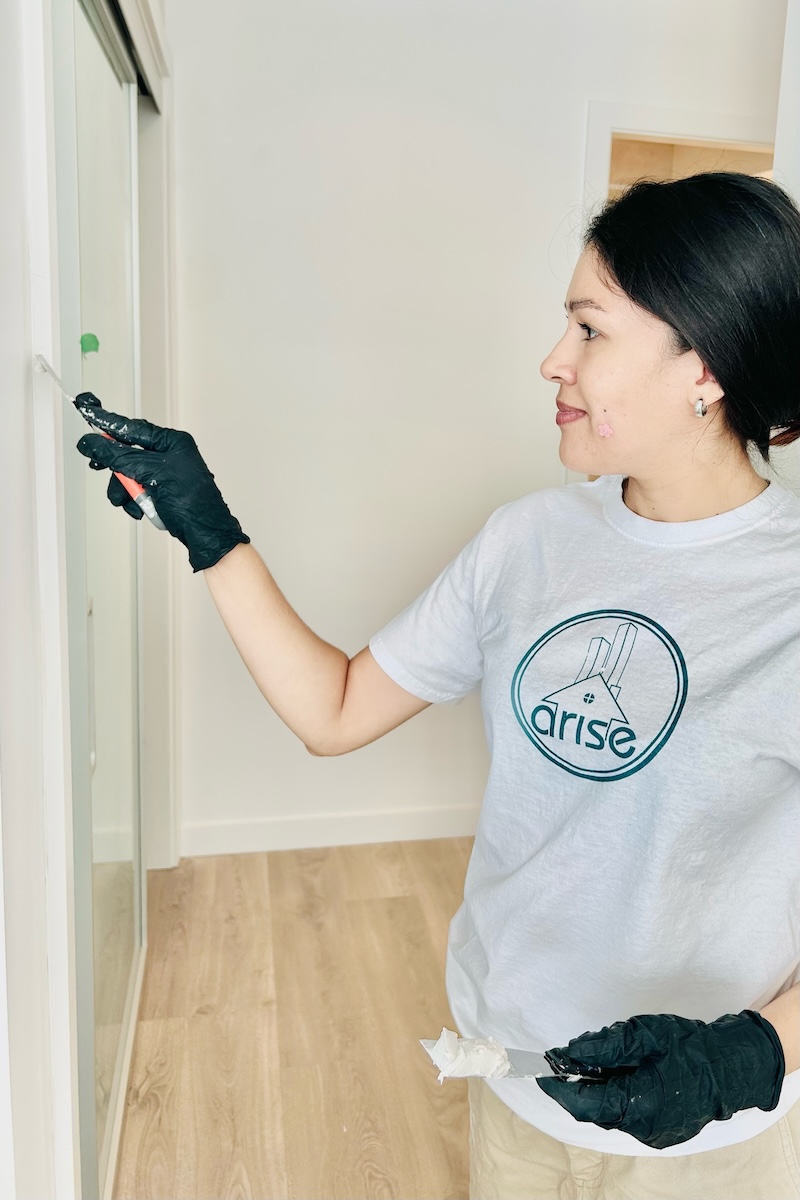 Arise worker fixing deficiency, applying drywall compound